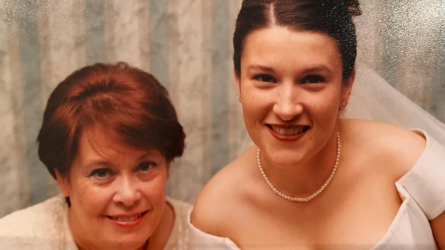 Hayley Bowen Two white women, the one on the left has short, reddish brown hair. The woman on the right has brown hair and is wearing a wedding dress and tiara