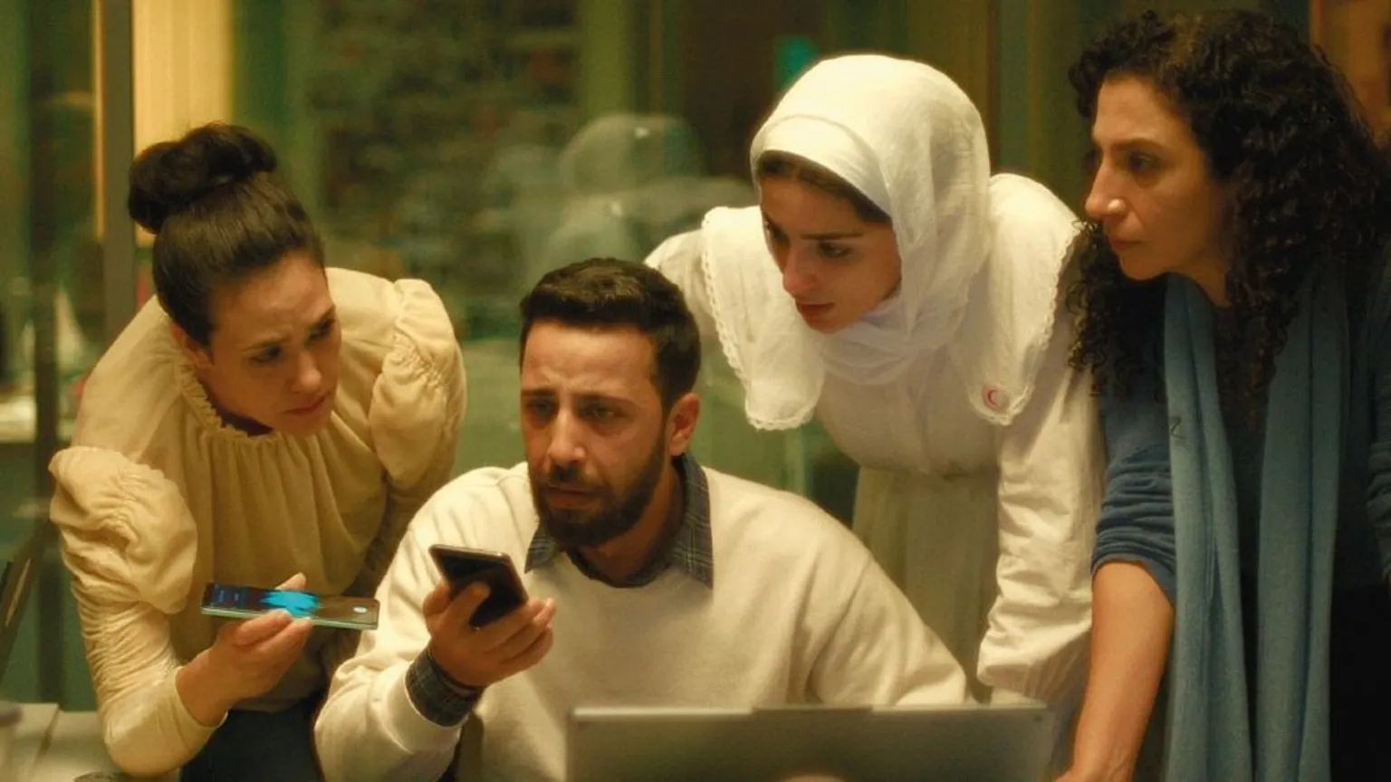 Altitude A group of staff in a call centre, crowding around a mobile phone