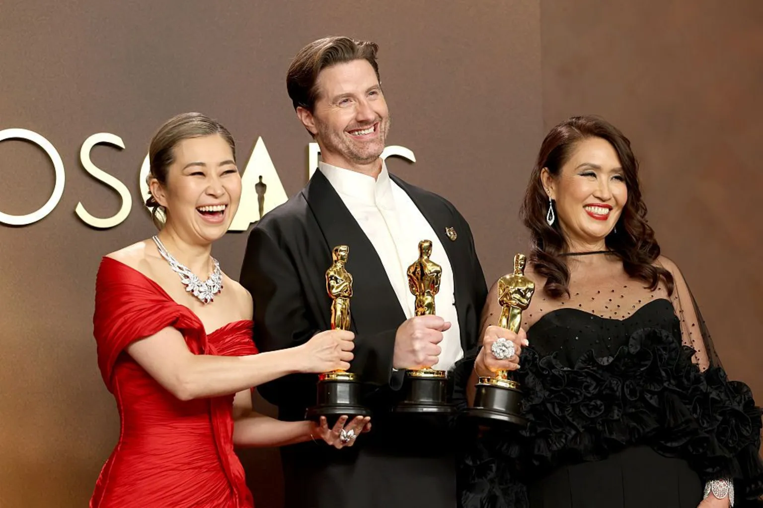  KPop Demon Hunters film-makers Maggie Kang, Chris Appelhans and Michelle LM Wong pose with their Oscars statuettes.