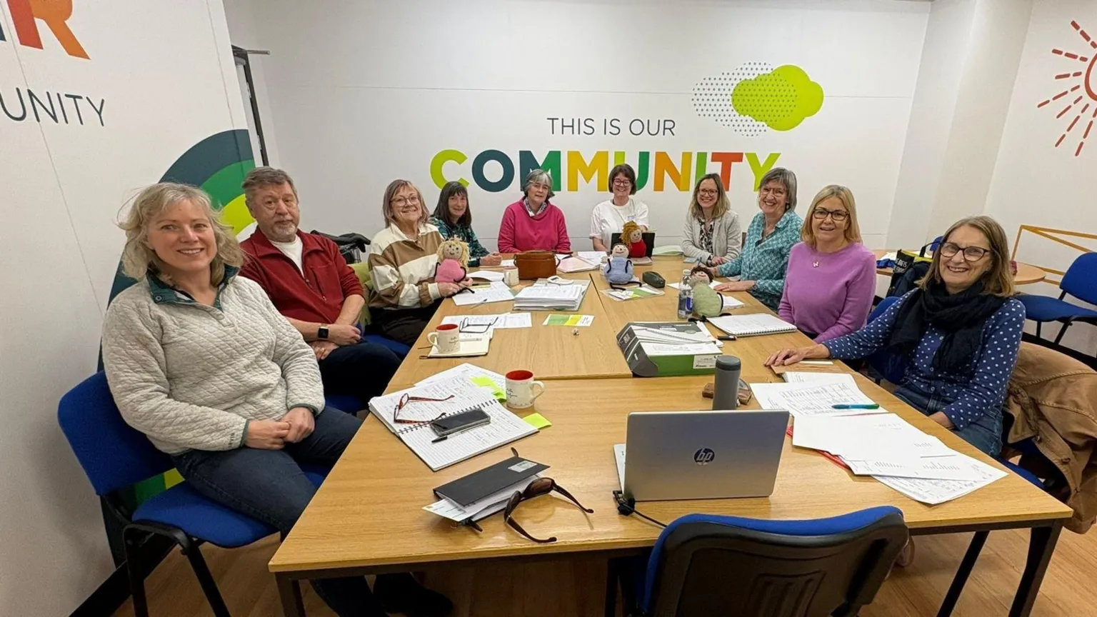Borders Children's Charity A group of men and women around a table facing the camera.