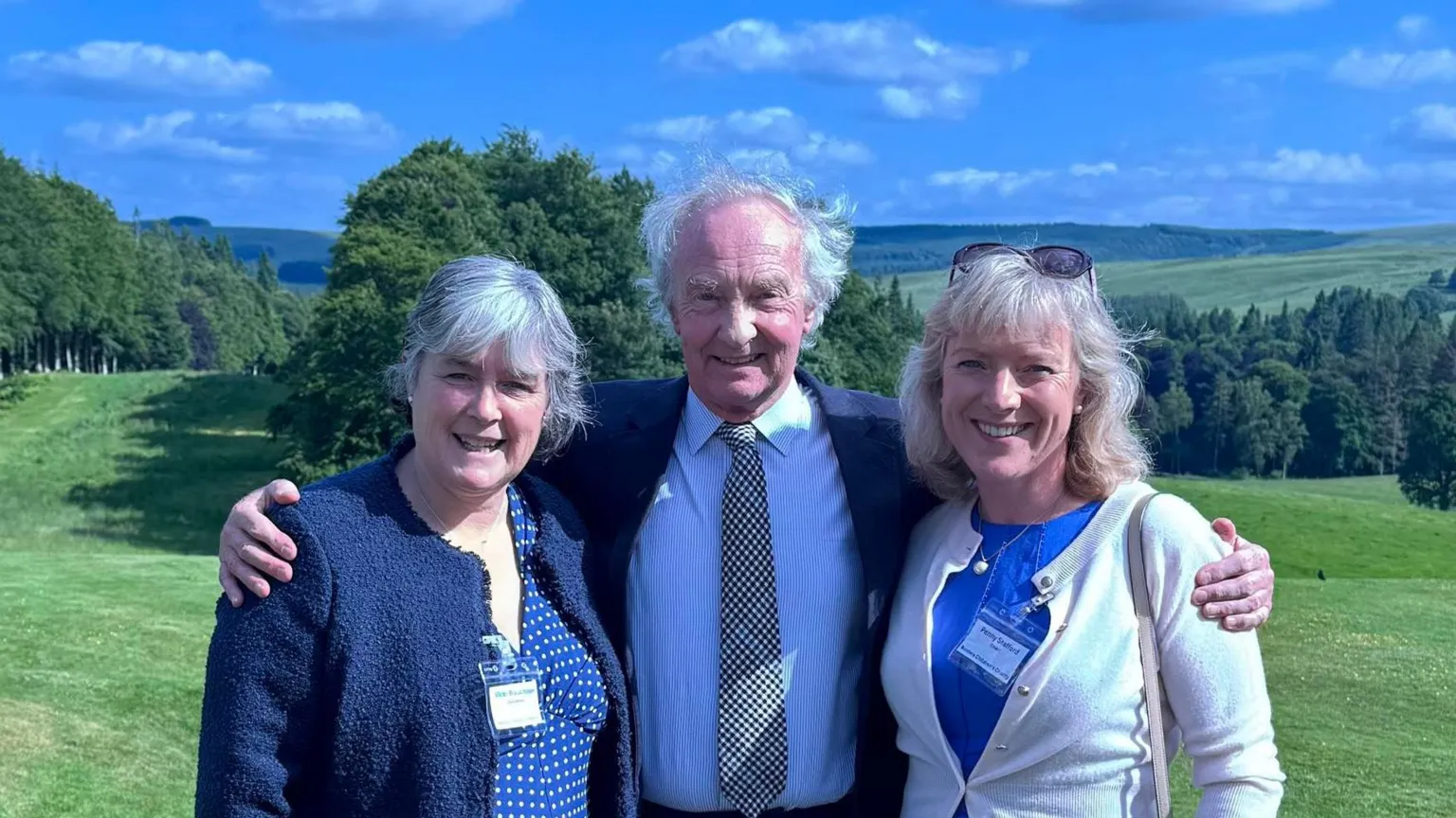 Borders Children's Charity Two women flank elderly man in shirt, tie and jacket looking at the camera