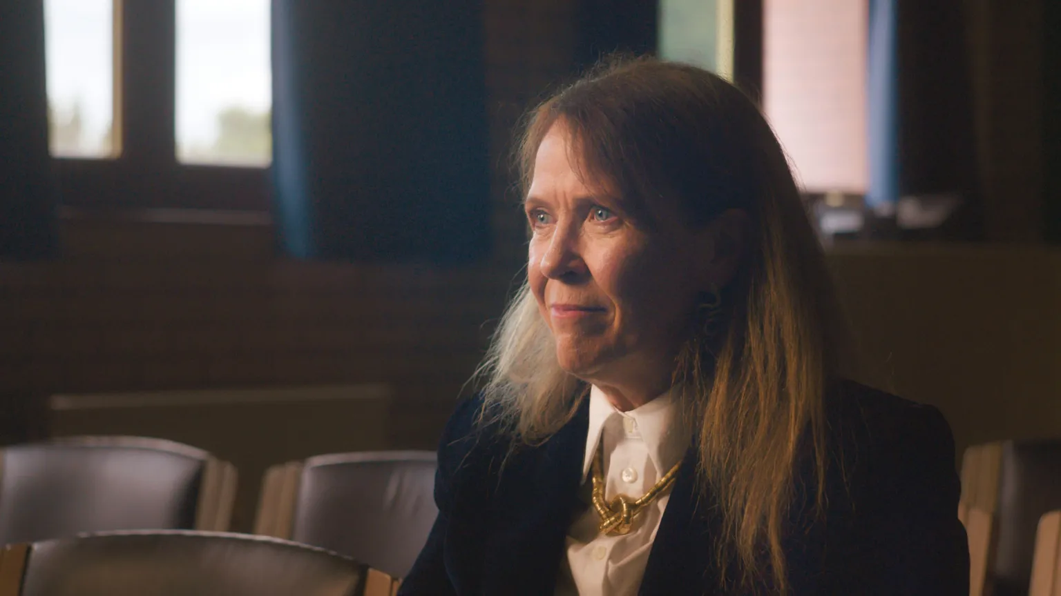 Head and shoulders image of Karyn McCluskey. She has long light red hair and is wearing a dark blazer with a white shirt. She has a gold necklace at her collar.