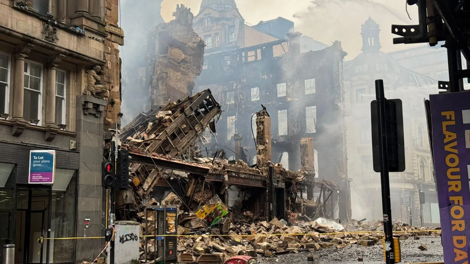 Network Rail The Union Corner building is reduced to rubble after a fire in Glasgow. Victorian buildings and street furniture surround the iron and sandstone remains.