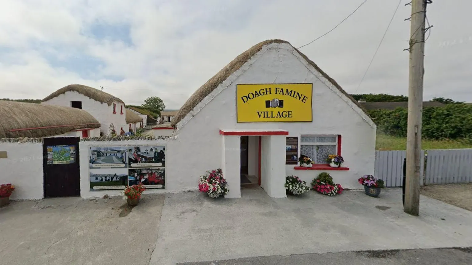 Google A white thatched building with a yellow sign above the door reading 