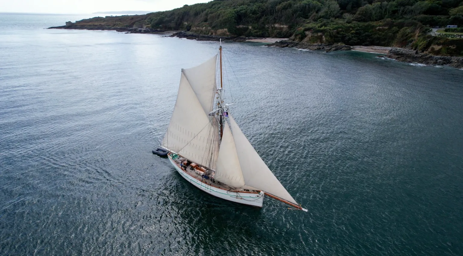 Turn to Starboard An ariel shot of the Pellew. It is a large ship with two large sails. The base of the boat is white. 