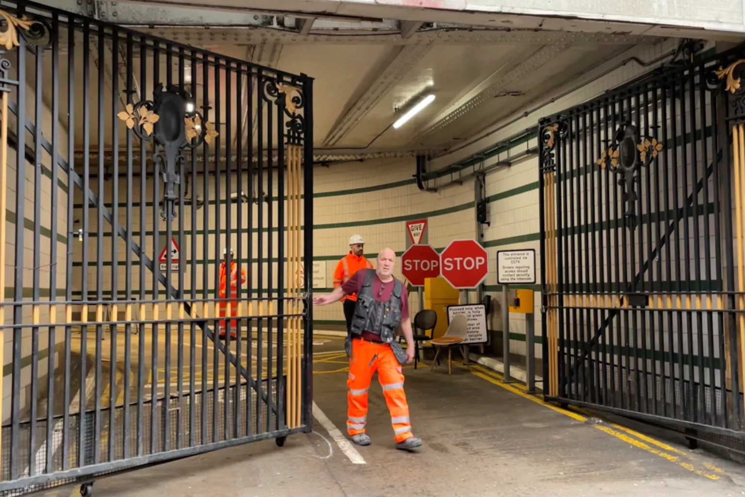 Men in work jackets at the arched railway entrance in Glasgow