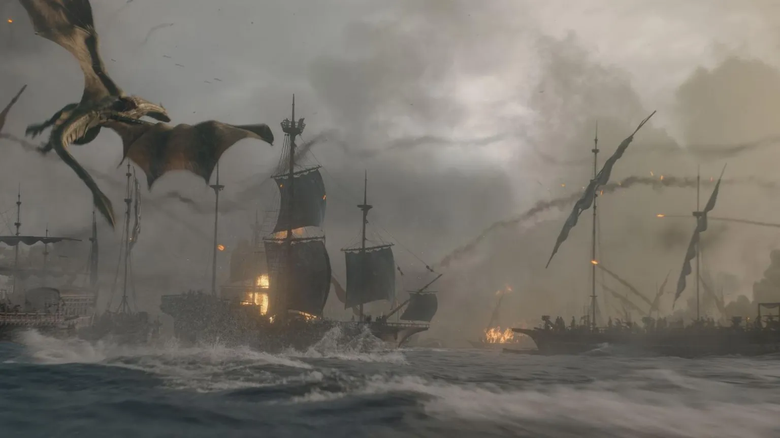 HBO Scene from the series: A fleet of tall ships mid-battle, smoke rising up into the deark sky. Huge waves crash in the foreground, while, in the background, two ships are on fire, with flame. A dragon circles the sky in the top left corner of the image.