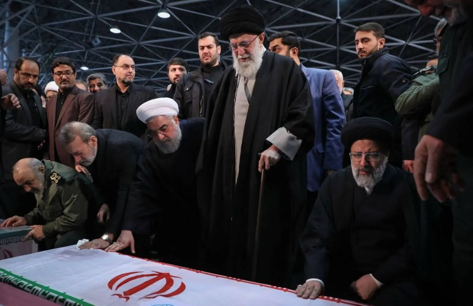 Anadolu via Larijani and other politicians and clerics stand near an Iran flag. 