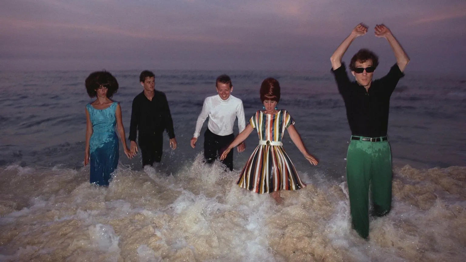  The B-52s wade through the surf against a sunset skyline in 1982