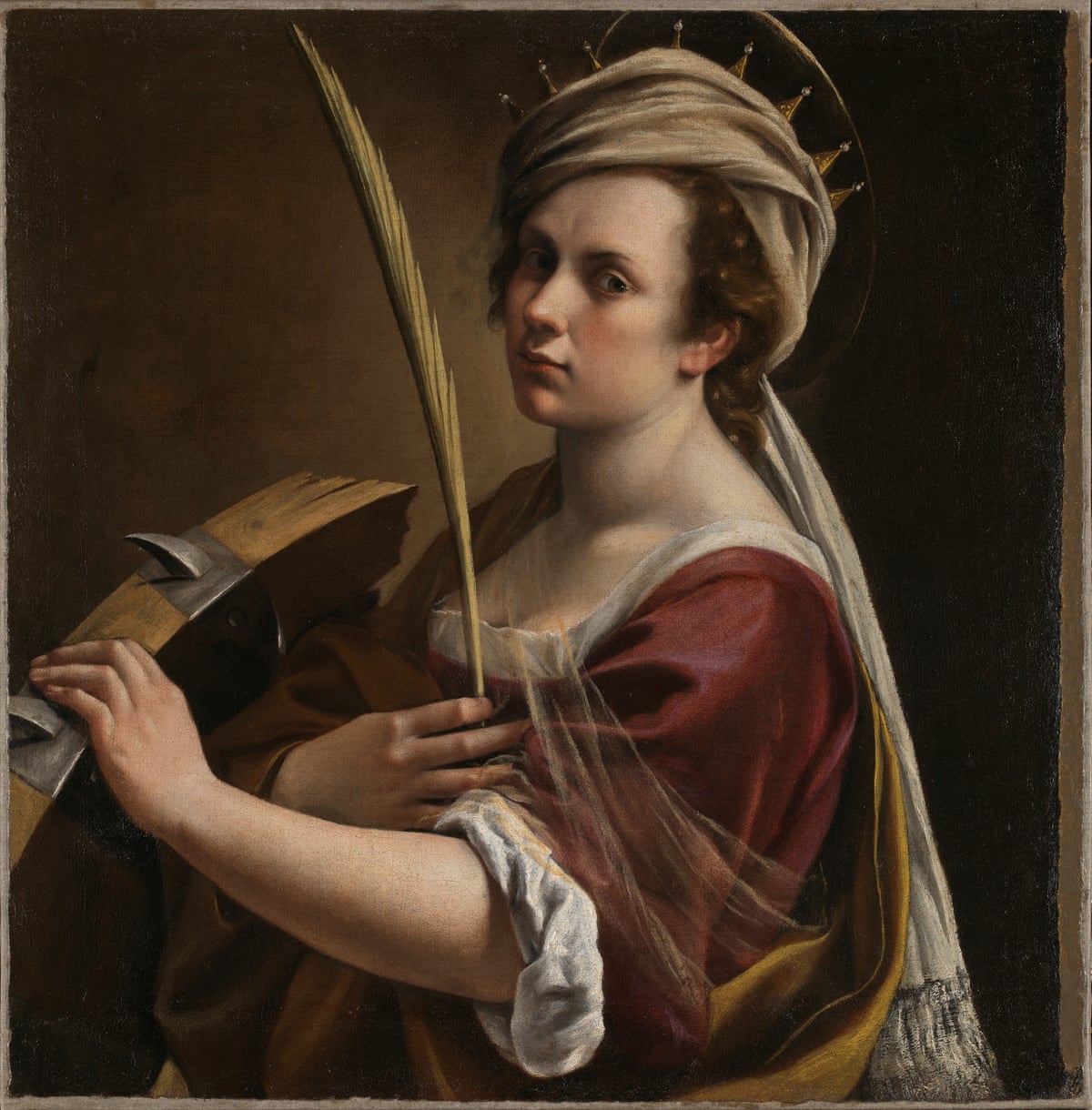 Woman holding a quill with one hand and the open lid of a trunk in the other in period dress