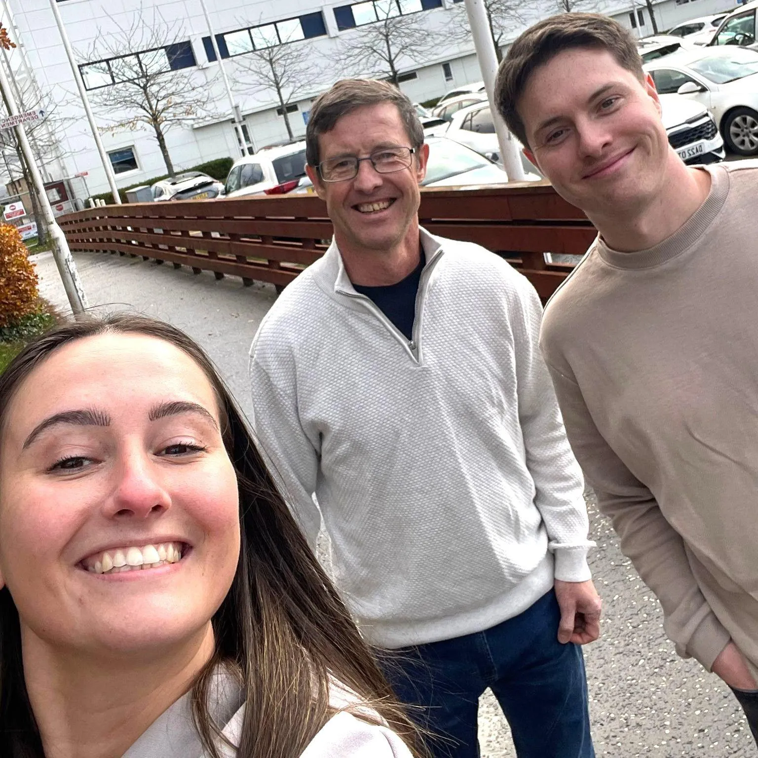 Ian Rodger with children Emma and Alex, smiling at the camera in a selfie, outside hospital.