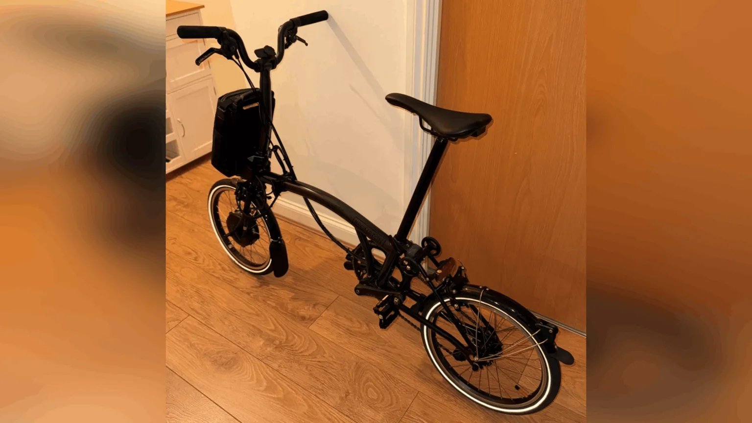 A black bicycle in a hallway.