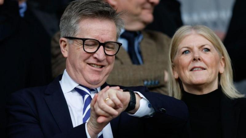 Andrew Cullen checks his watch in the stands during a Portsmouth game