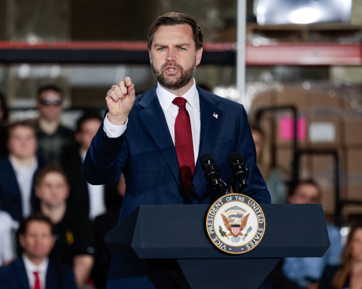 JD Vance in a suit giving a speech to a crowd of people
