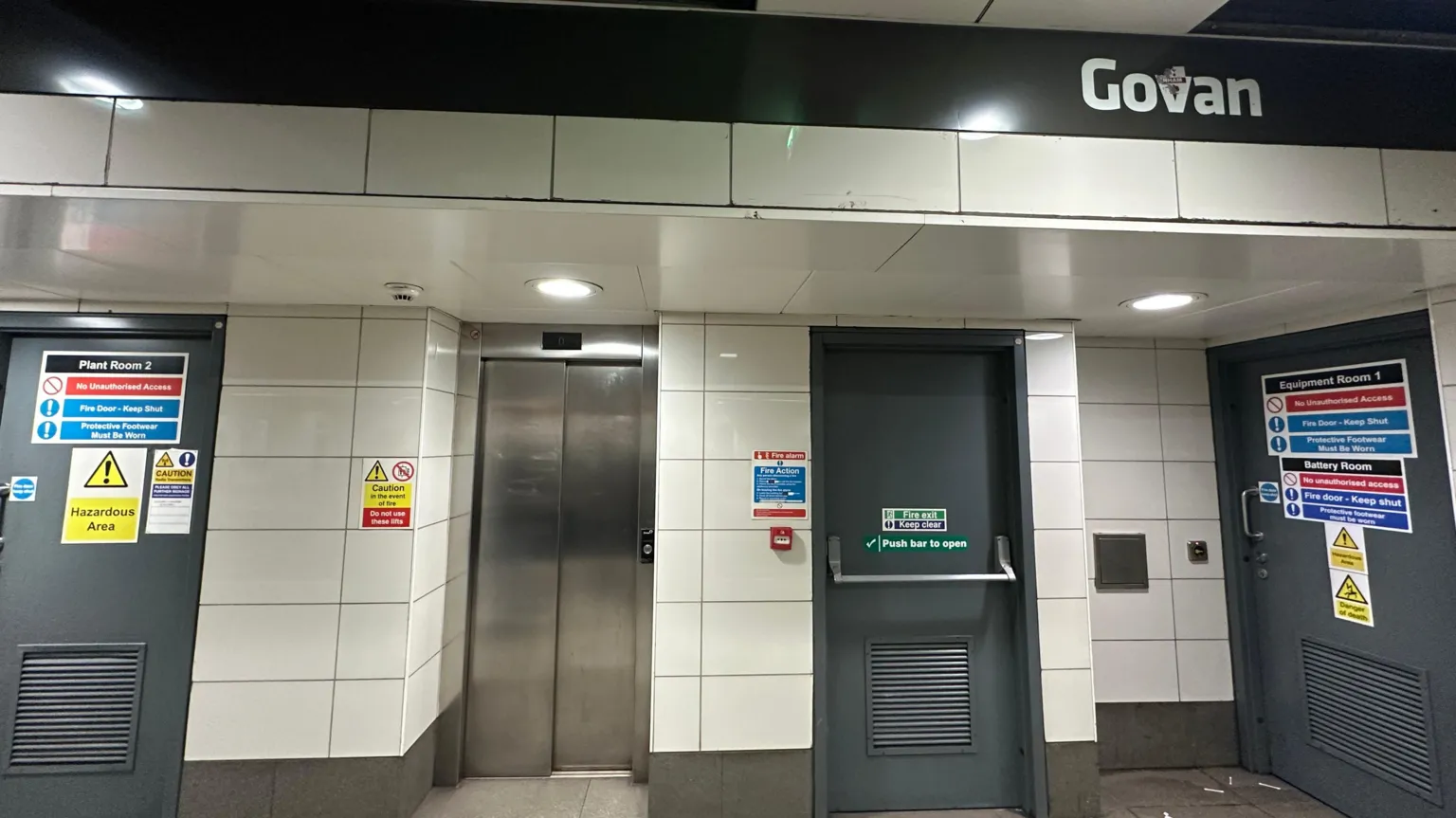A lift in between two fire doors with a sign above saying Govan.