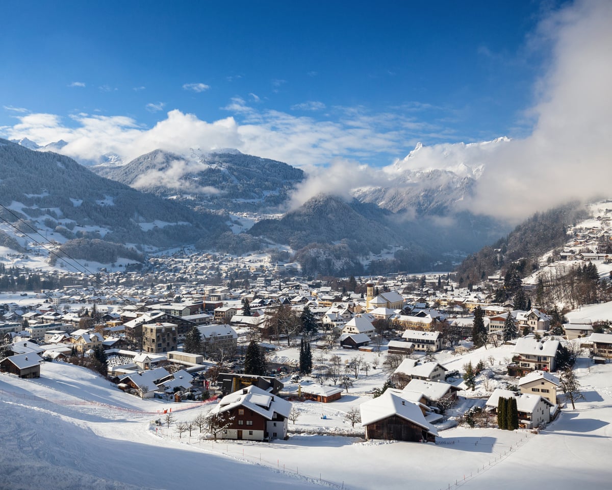 snowy town encircled by peaks