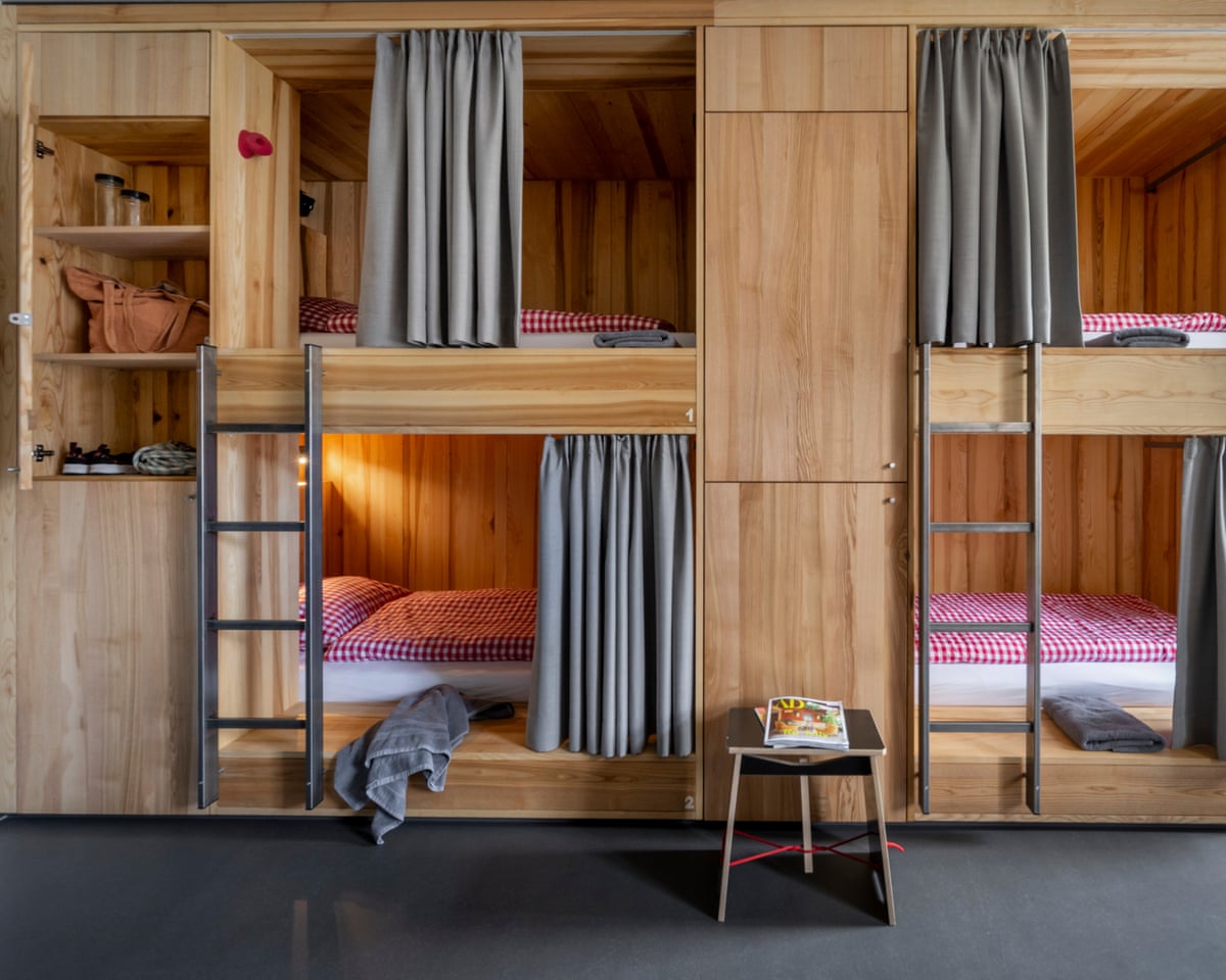 a block of four wooden sleeping pods on two levels with lockers for belongings