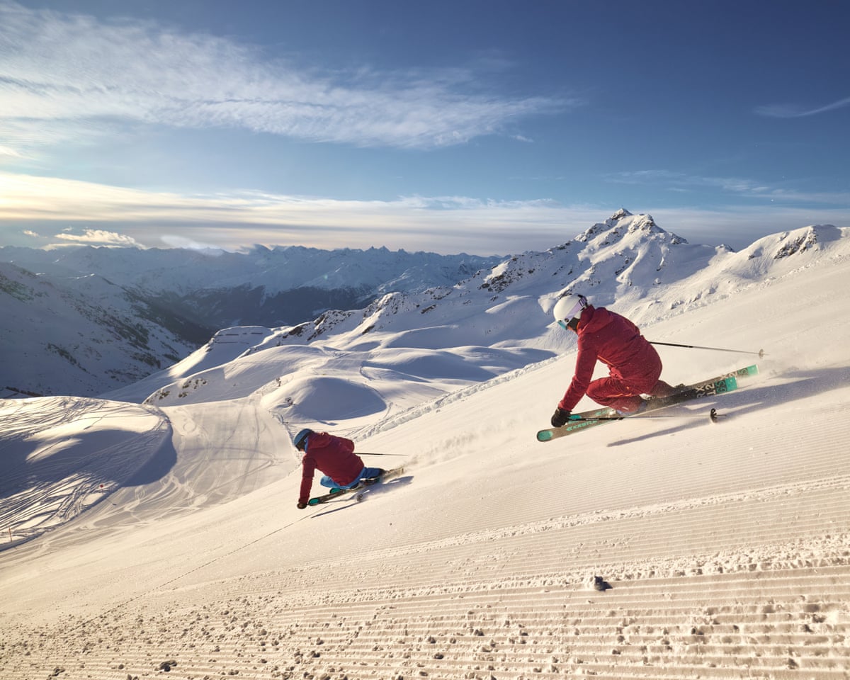 Two skiiers head down a slope