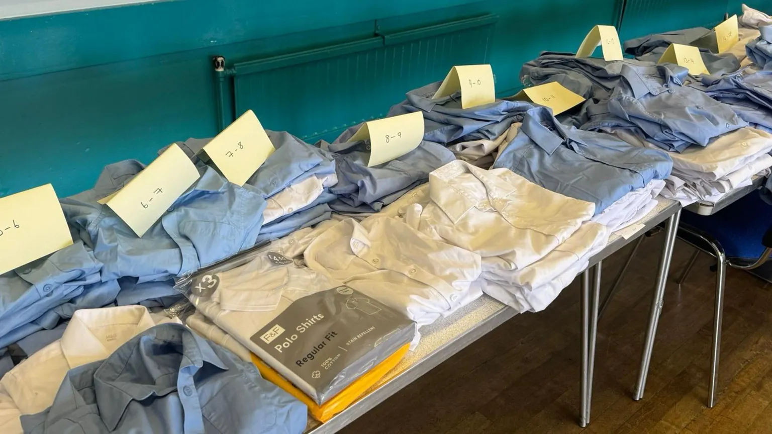 Piles of new and donated uniforms arranged in order of age