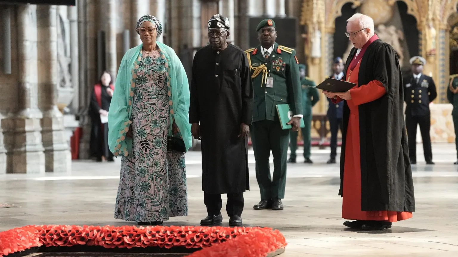  President of Nigeria Bola Ahmed Tinubu and First Lady Oluremi Tinubu stand in front of the Grave of the Unknown Warrior, a memorial stone framed with red poppies, during a visit to Westminster Abbey.