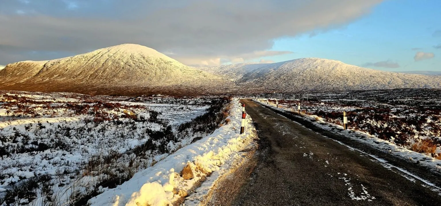 Victor Tregubov A snowy scene of a mountain with a road in the foreground
