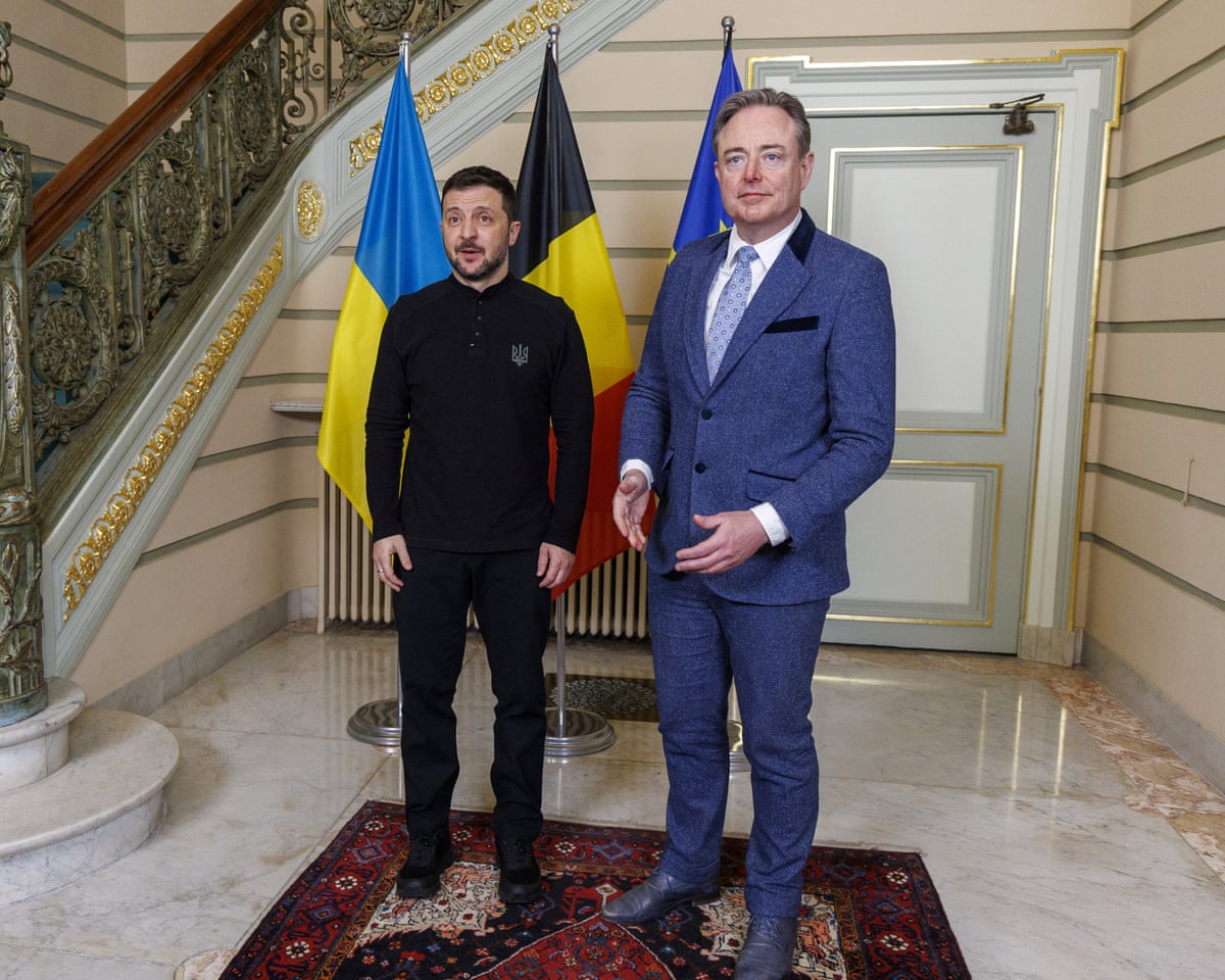 The two men standing next to an ornate staircase