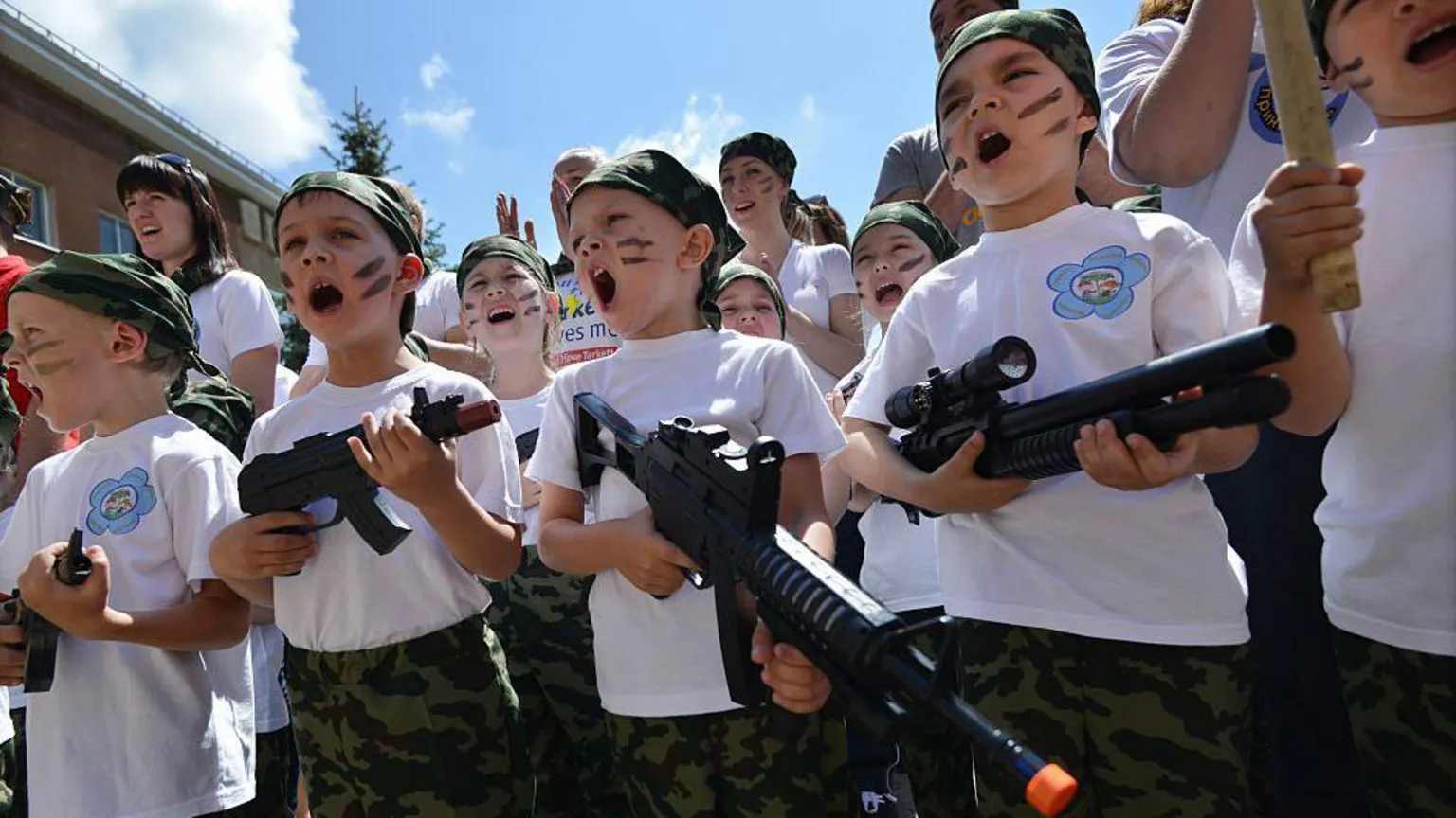 AFP via Children scream while holding toy rifles during the military-patriotic game