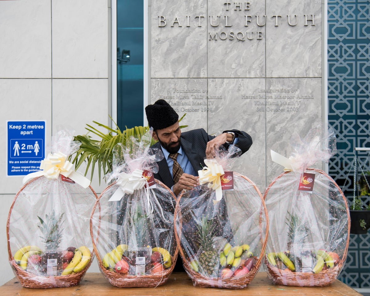 A volunteer prepares to give out fruit baskets to worshipers outside a mosque