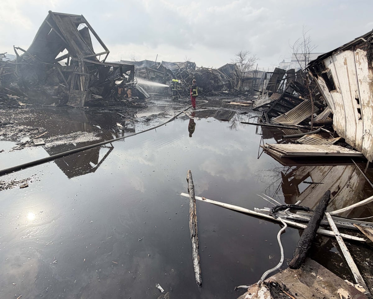Emergency worker puts out fires in the wreckage of a bombed building