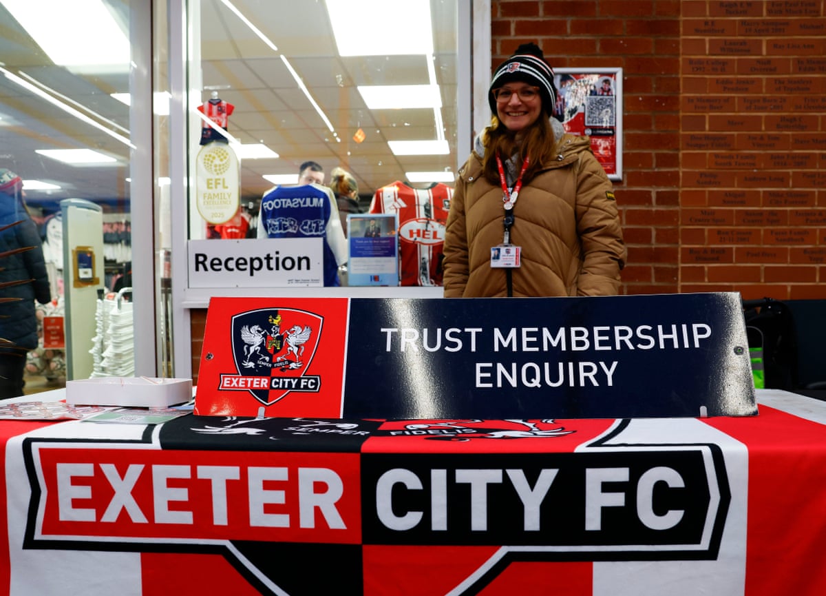 Women behind table with ‘Trust membership enquiry’ and ‘Exeter City FC’ in front