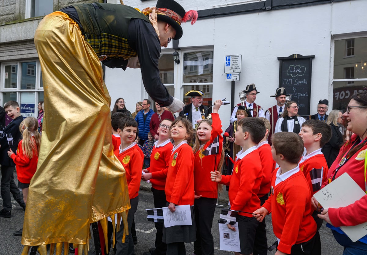 Children gaze up at a stilt walker.