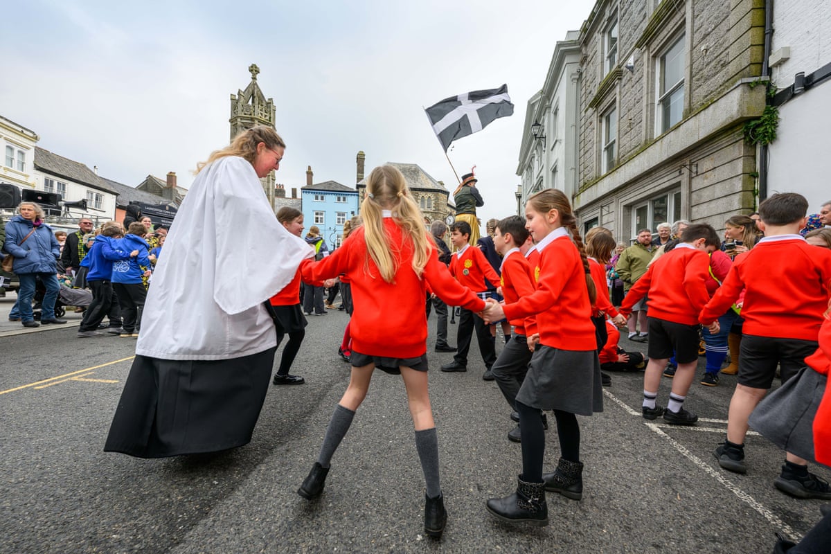 Children dancing in a circle with a vicar.