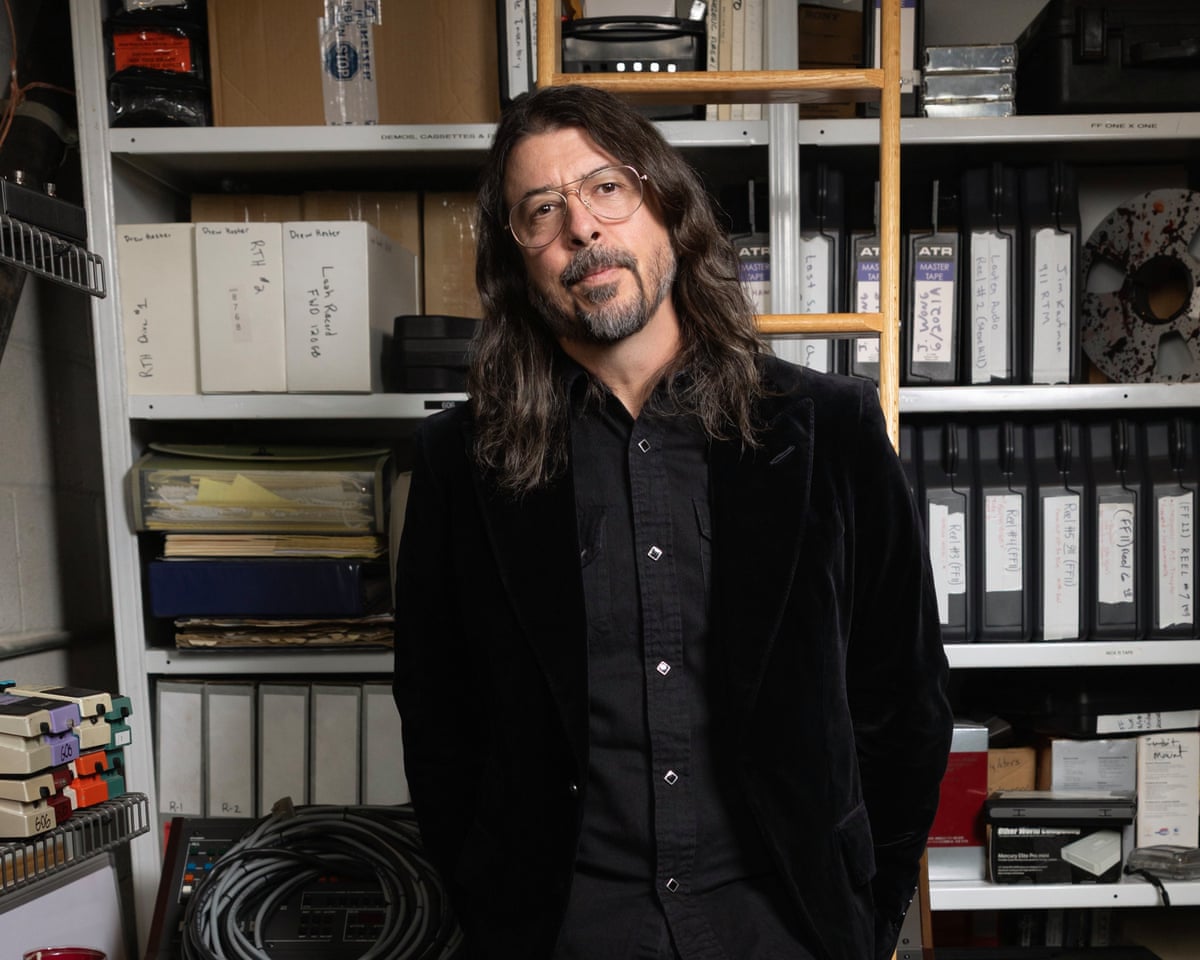 Dave Grohl in Los Angeles, standing in an office with a wooden ladder behind him.