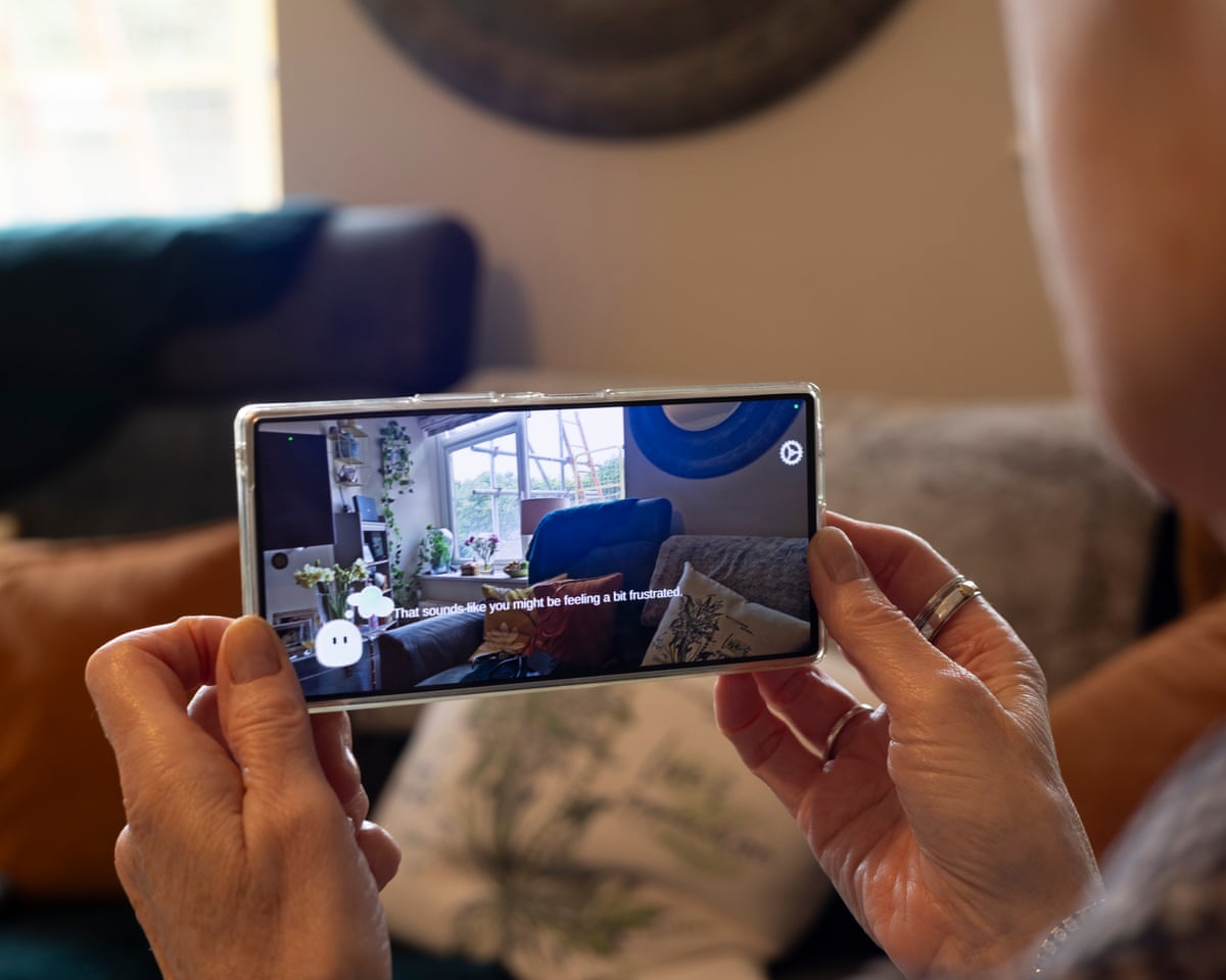 Carole Greig holds her phone which is showing text from the AI helper that says ‘That sounds like you might be feeling a bit frustrated’