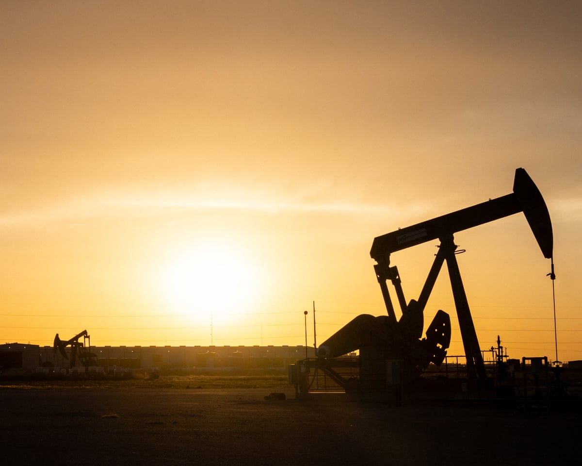 A oil pump jack is seen in shadow at sunset in Midland, Texas.