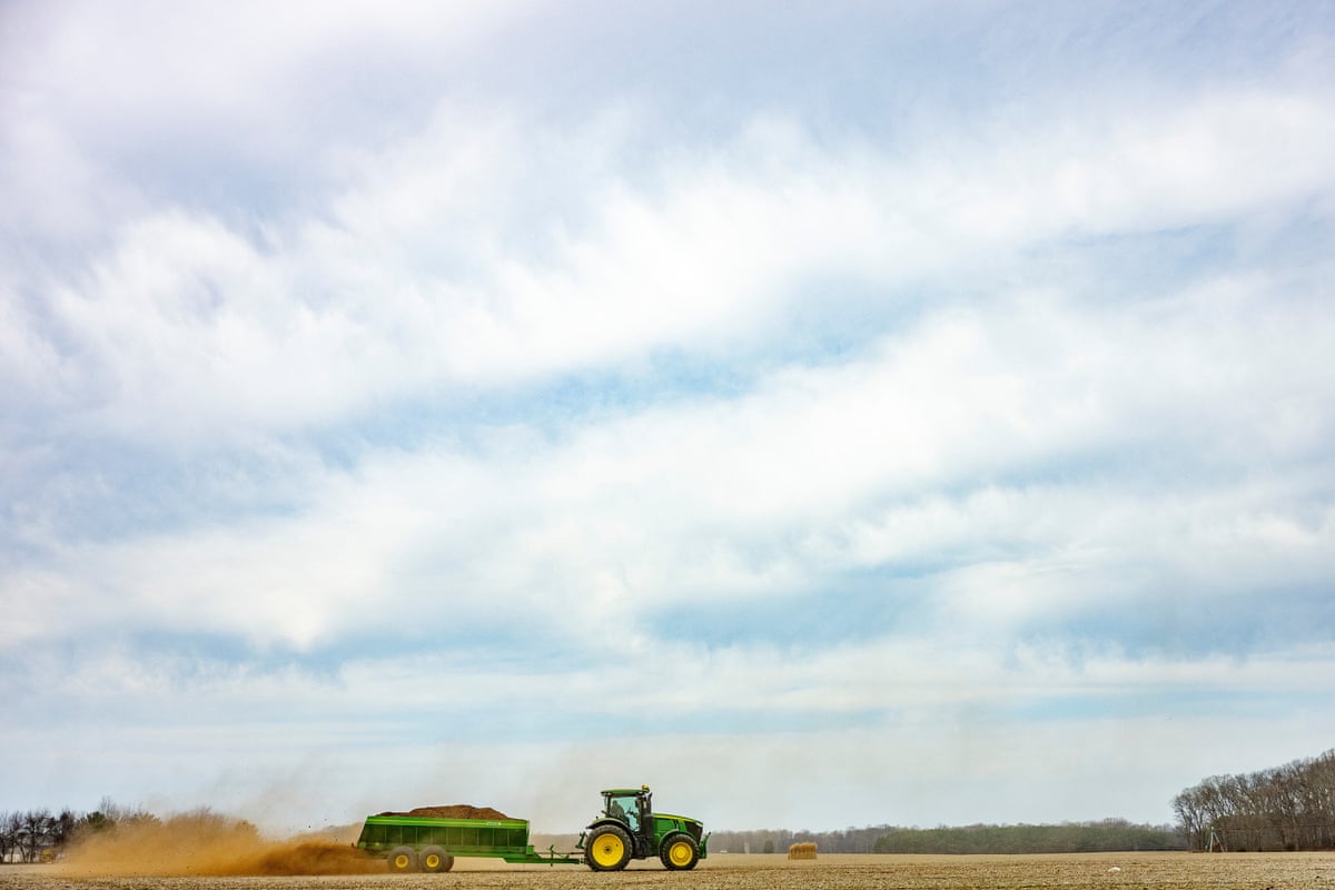 A tractor lays fertilizer on a field at a farm