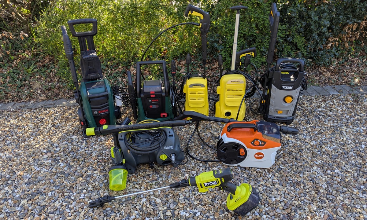 Eight pressure washers on a gravel driveway