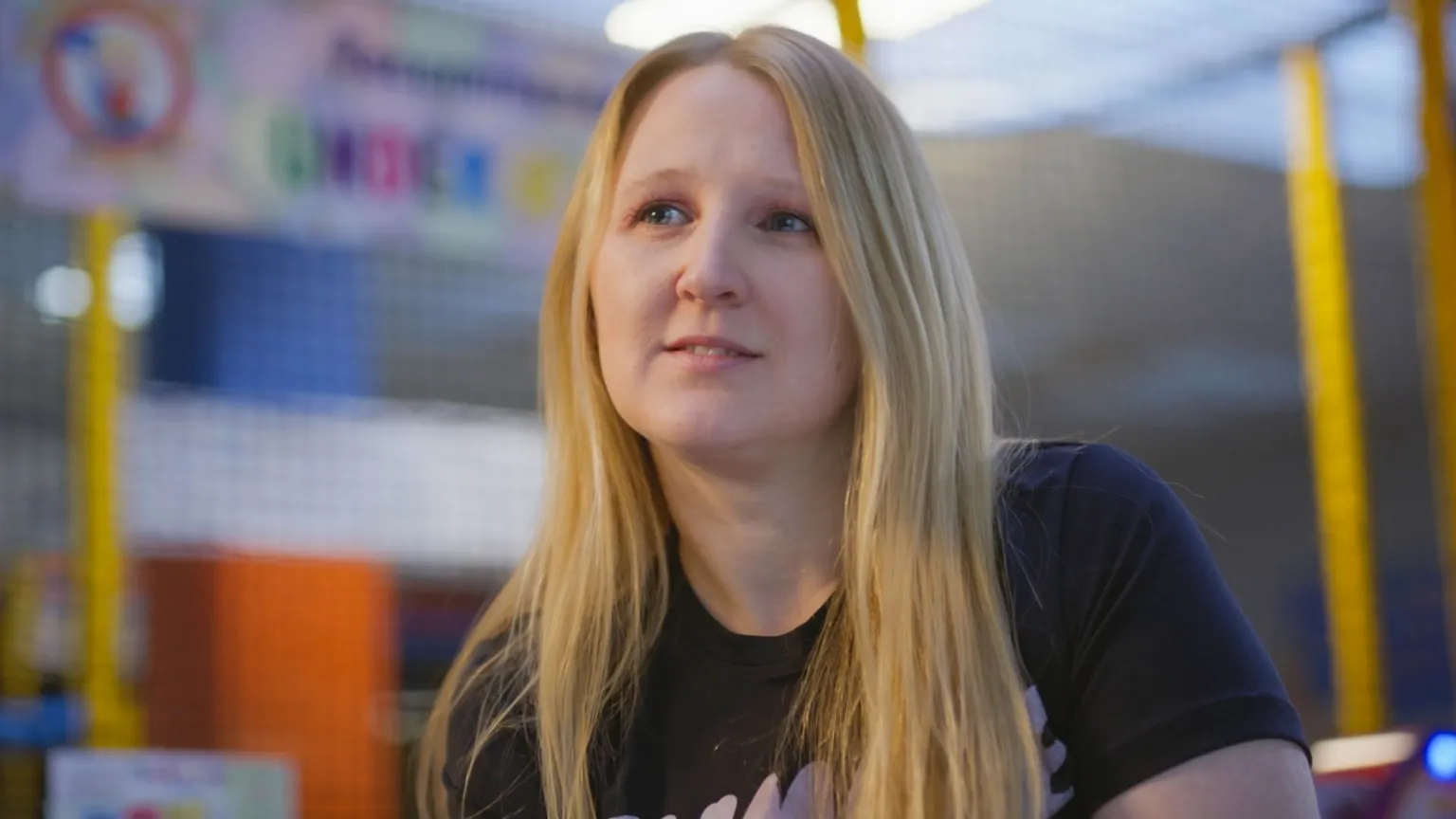 Emily Walsh with long straight blonde hair sitting in a soft play background
