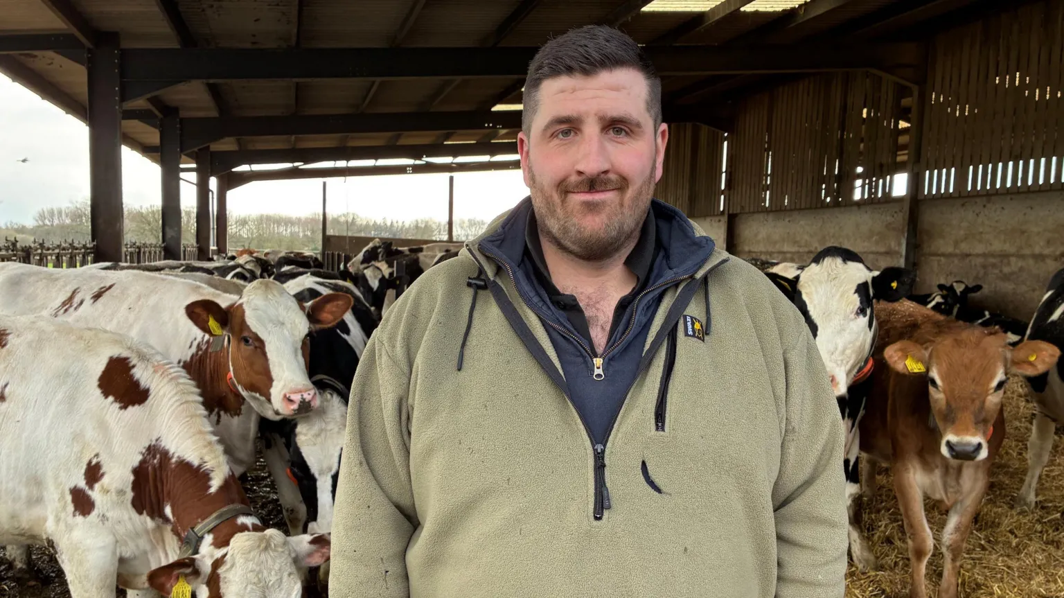 Mike Catley stood in front of his cows on a farm