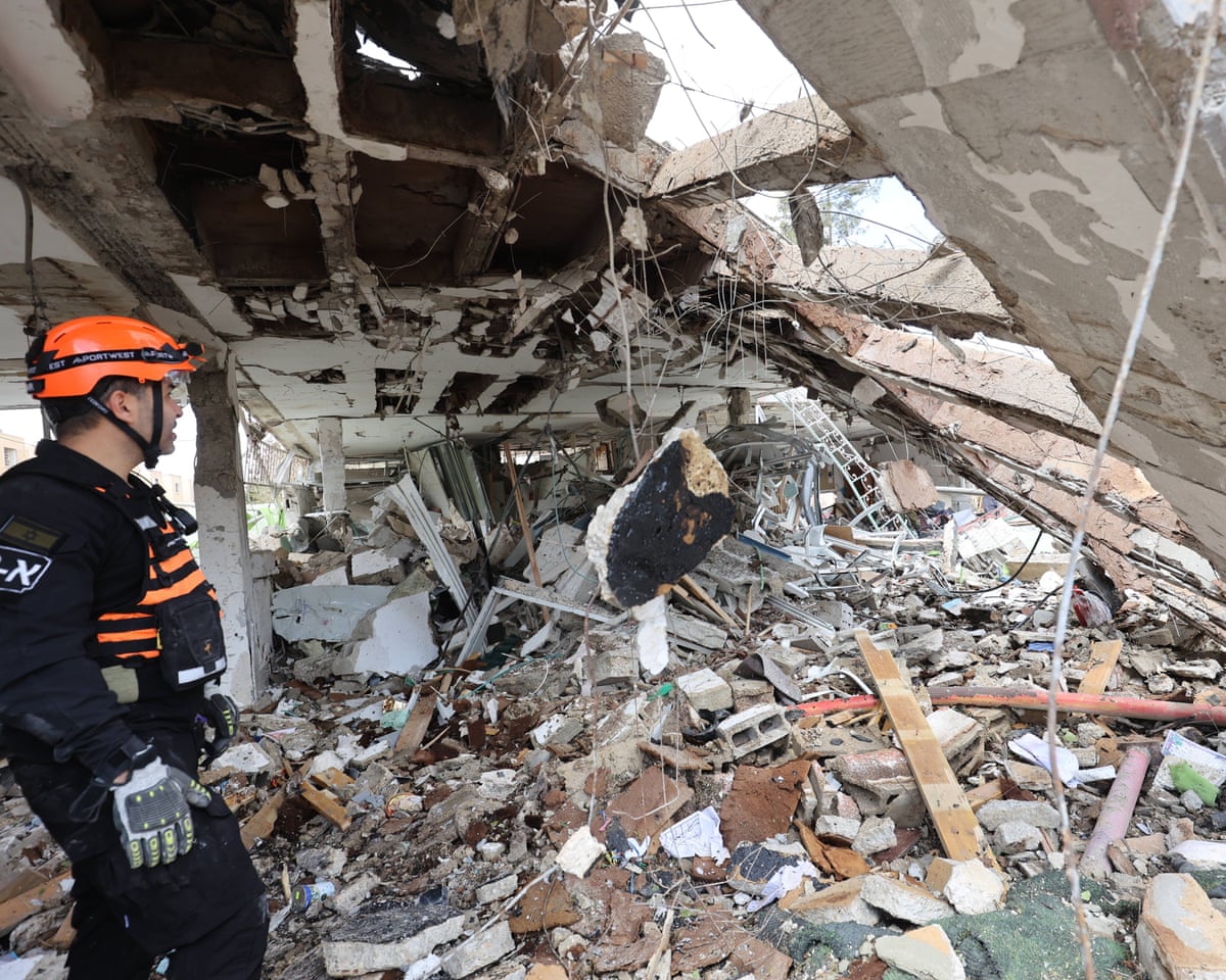 Israeli security forces and rescue teams search the scene of an Iranian strike in southern Israeli city of Dimona in the Negev desert on Sunday