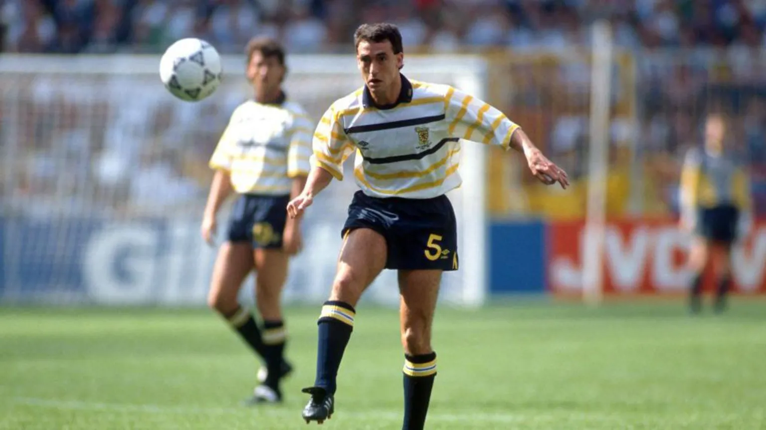  Scotland players wearing white shirts with blue and yellow hoops, blue shorts and blue socks during the 1990 World Cup.