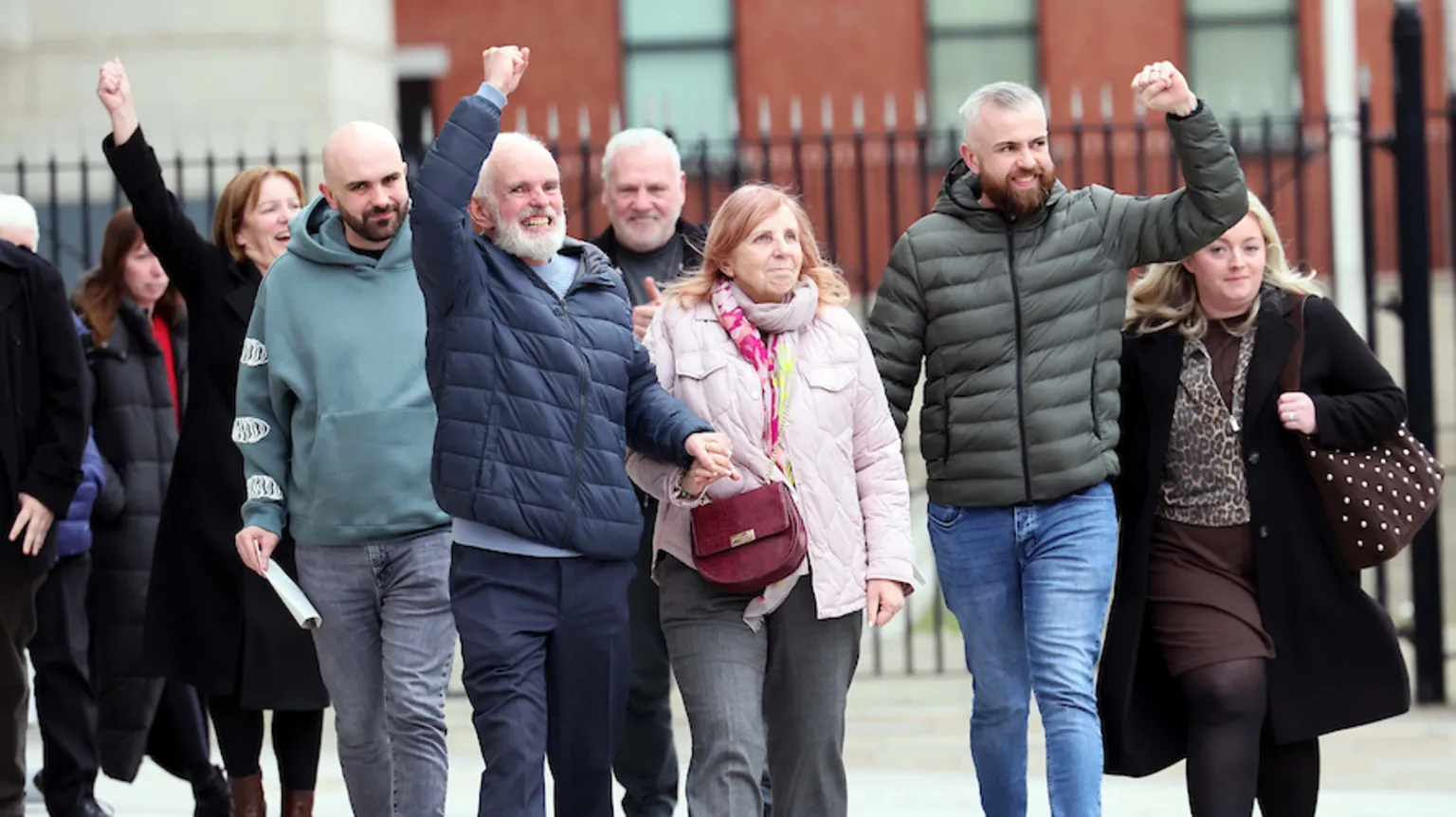 Pacemaker The family of Natalie McNally - her dad in a navy coat, mum in a pink coat and her brothers either side of them in green. Most of them have their fists raised in a show of victory.