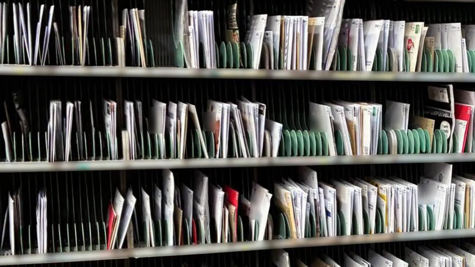 Supplied Racks on shelves filled with letters in a Royal Mail sorting office
