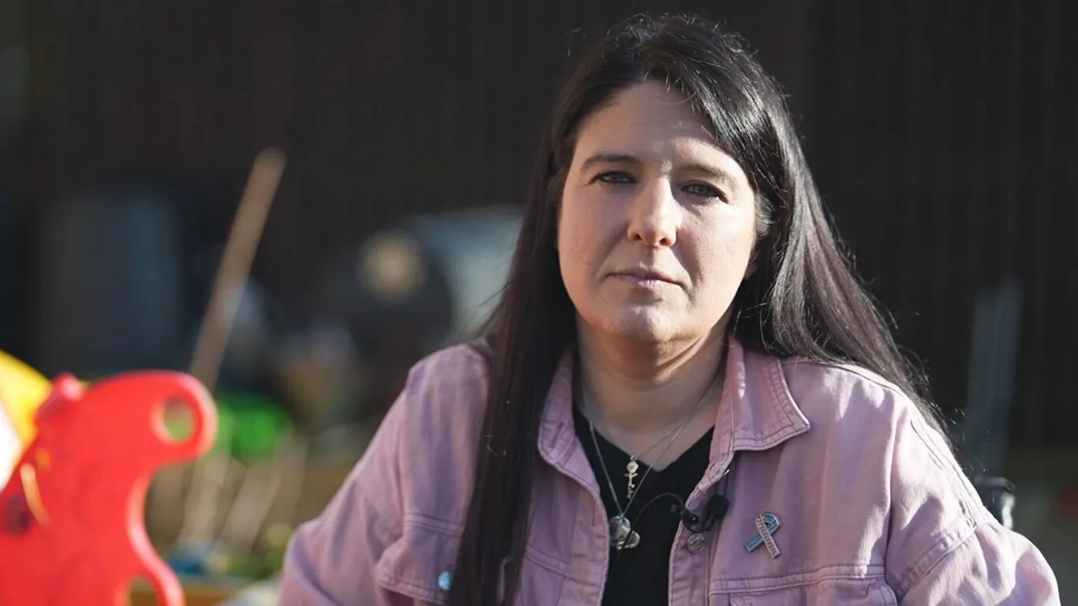 Zara Gavin has long black hair and is wearing a lilac denim jacket over a black top.