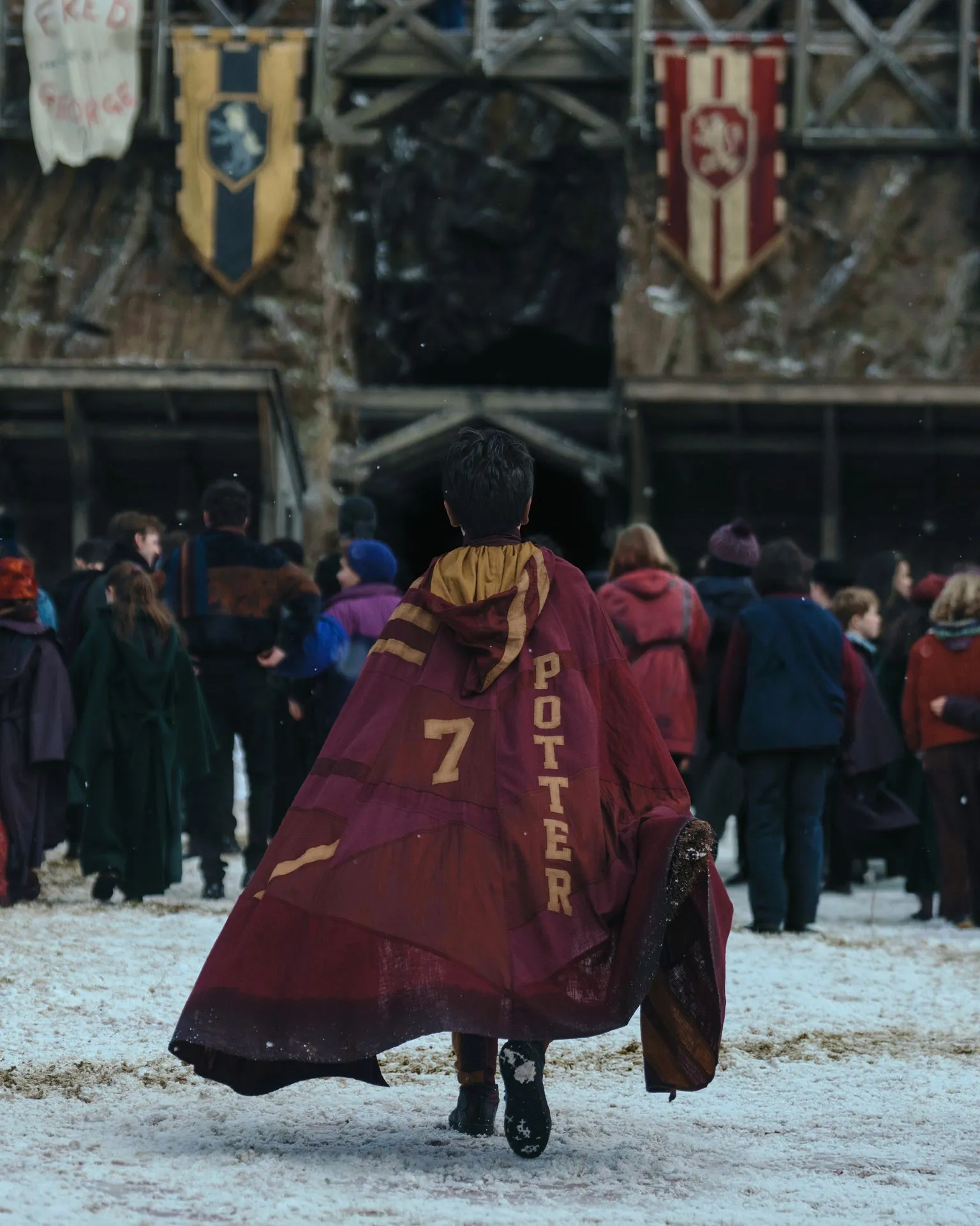 Aidan Monaghan/HBO Dominic McLaughlin as Harry Potter seen from behind in a long red cloak with