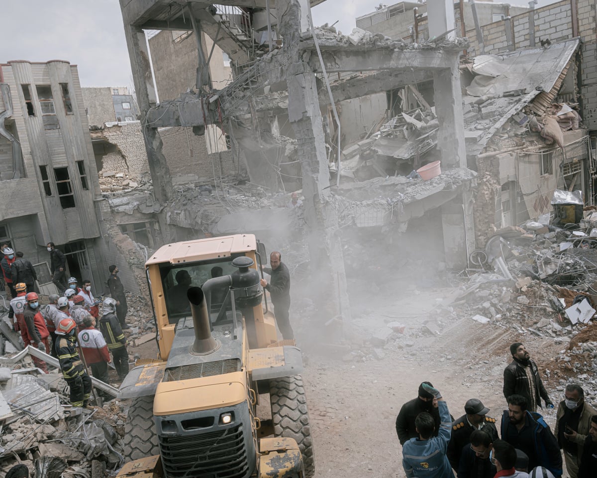 First responders use an excavator to clean the debris and search for victims at a residential building hit in an overnight strike in Tabriz, in north-western Iran’s East Azerbaijan province, on Tuesday