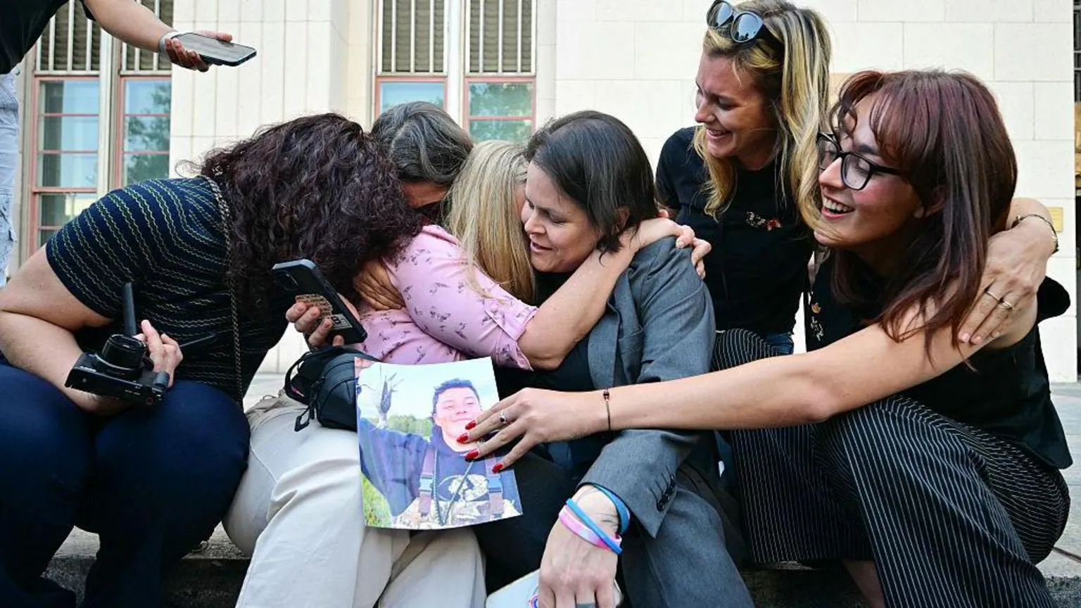 AFP via A plaintiffs' attorney for the Social Media Victims Law Center embracing family members of victims on the steps outside the Los Angeles Superior Court on Wednesday.