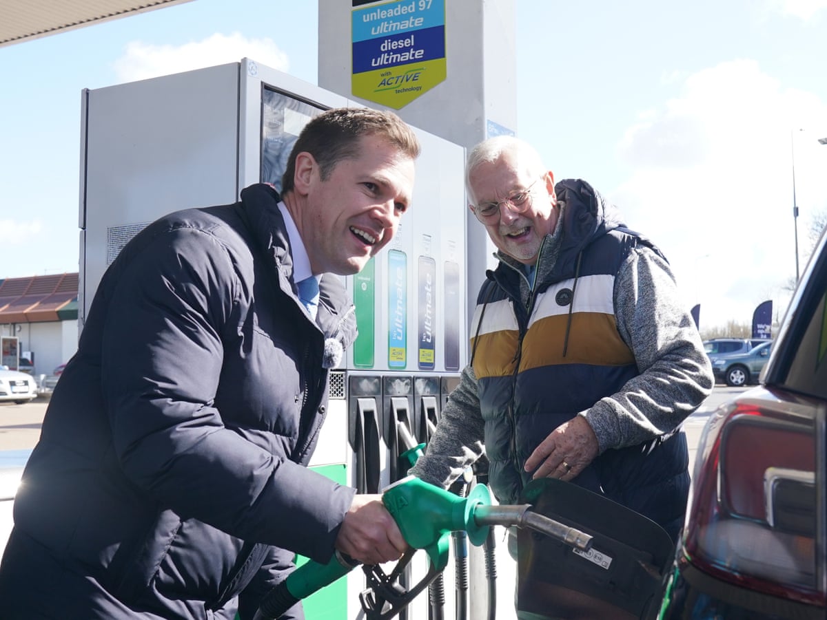 Robert Jenrick at the Whitfield Service Station in Dover, Kent, helping a driver fill up.