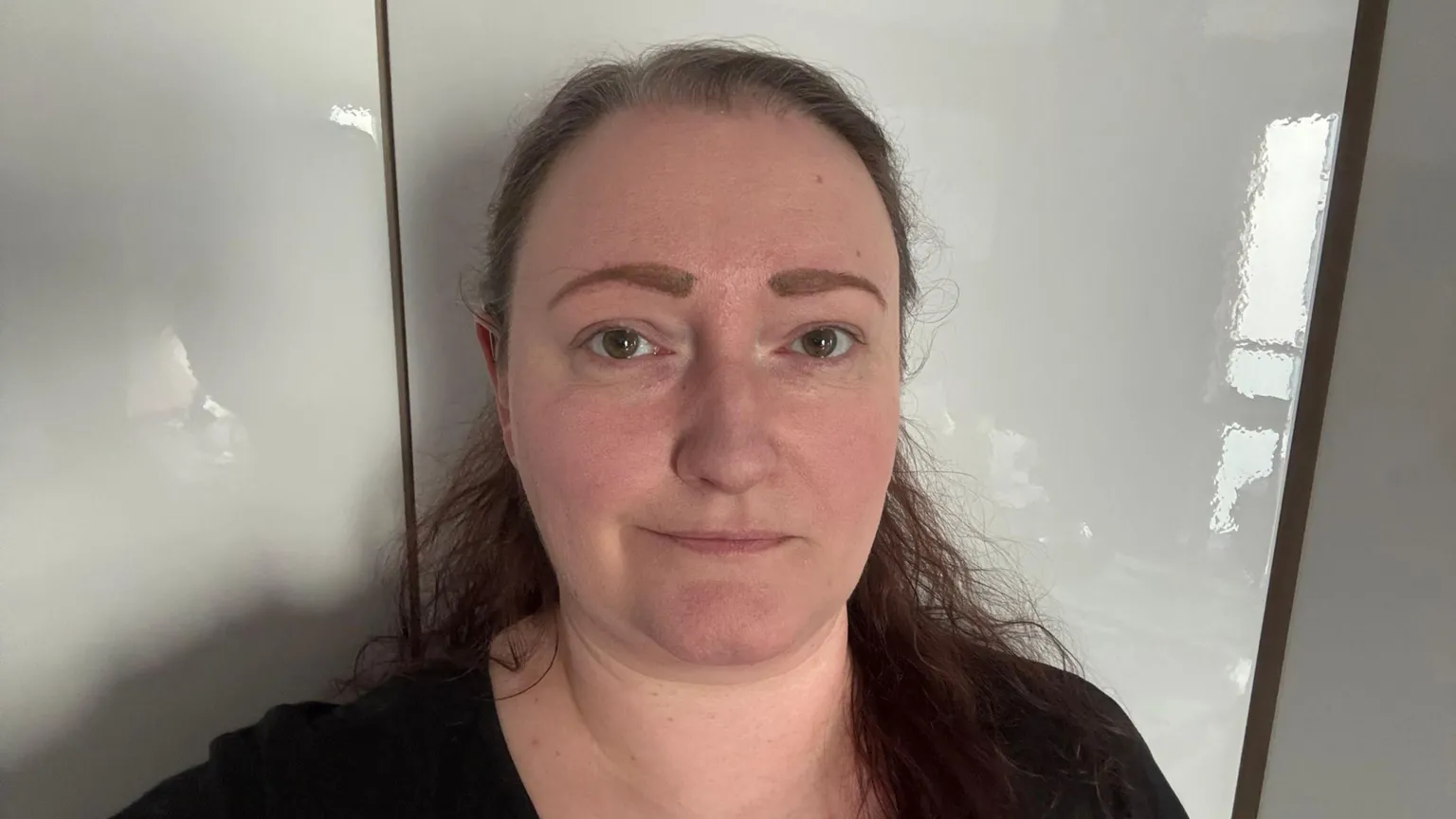 Jax Newman Headshot of a woman with brown hair against a plain white background. She has a slight smile but is looking quite serious.