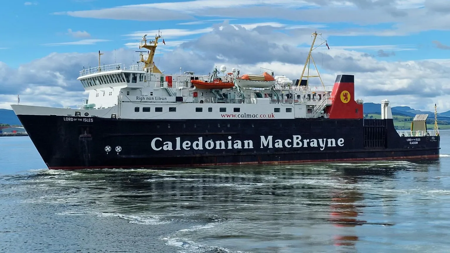 Christopher Brindle A black and white ship with red funnels. Caledonian MacBrayne is written on the side. There are blue skies and clouds in the background